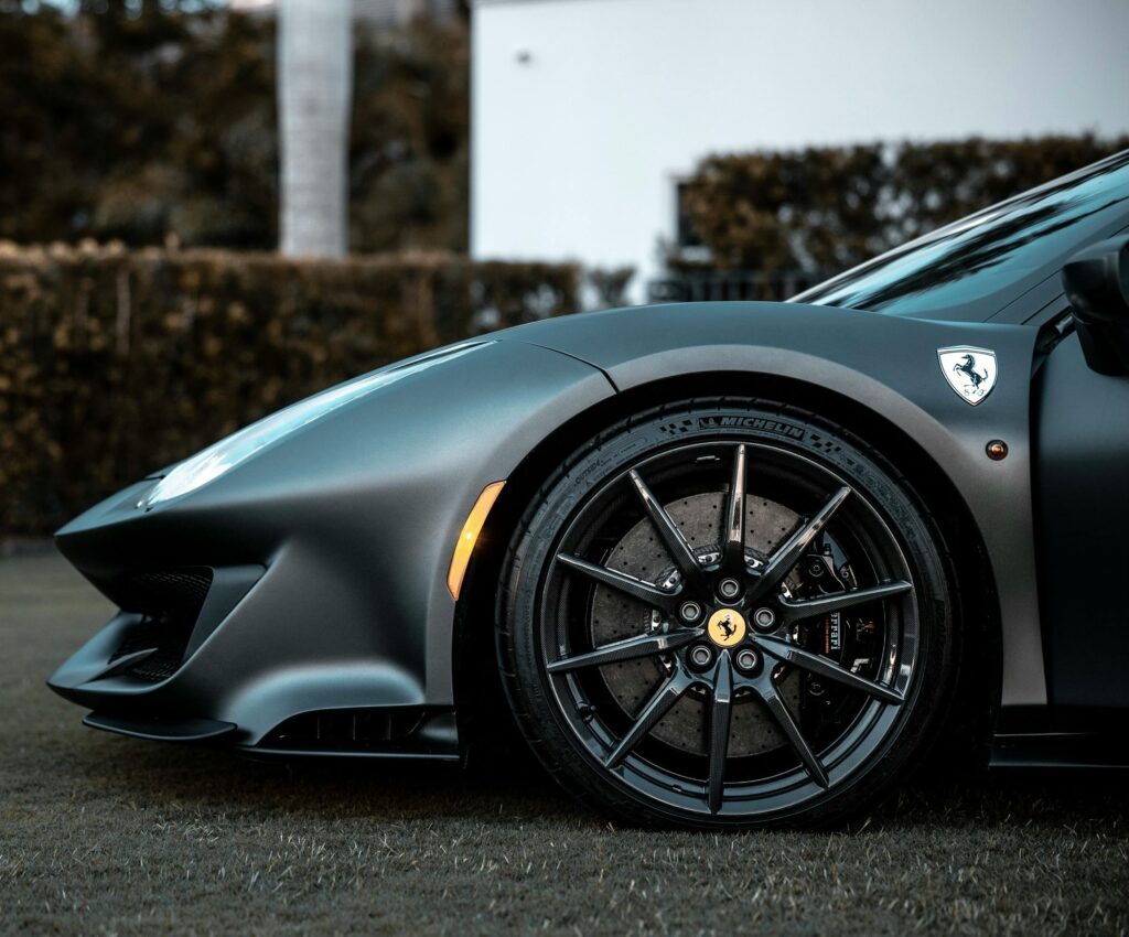 Detailed close-up of a luxury supercar wheel and front on grass.