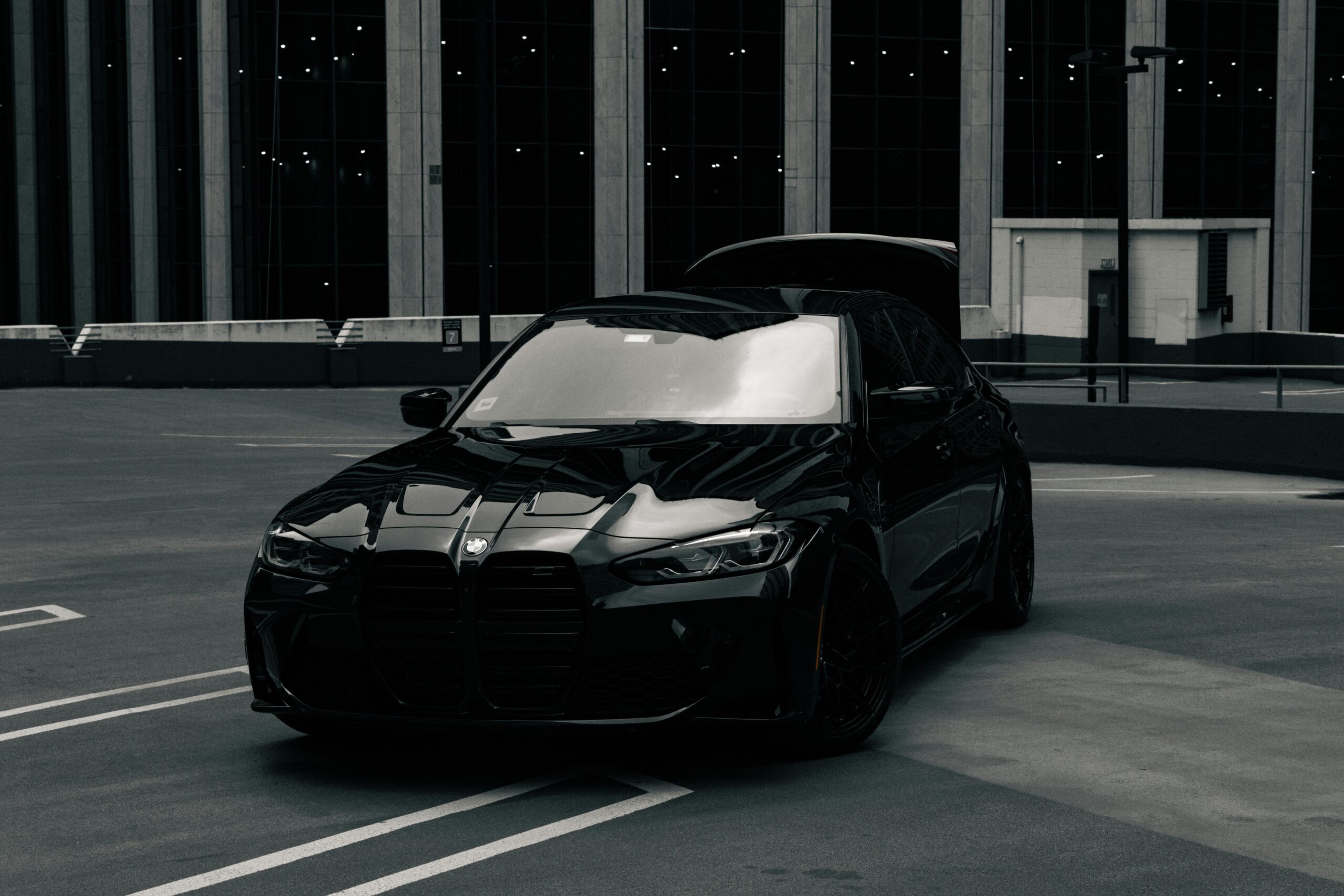 A stylish black BMW M3 on a rooftop in Chicago with skyscrapers in the background.