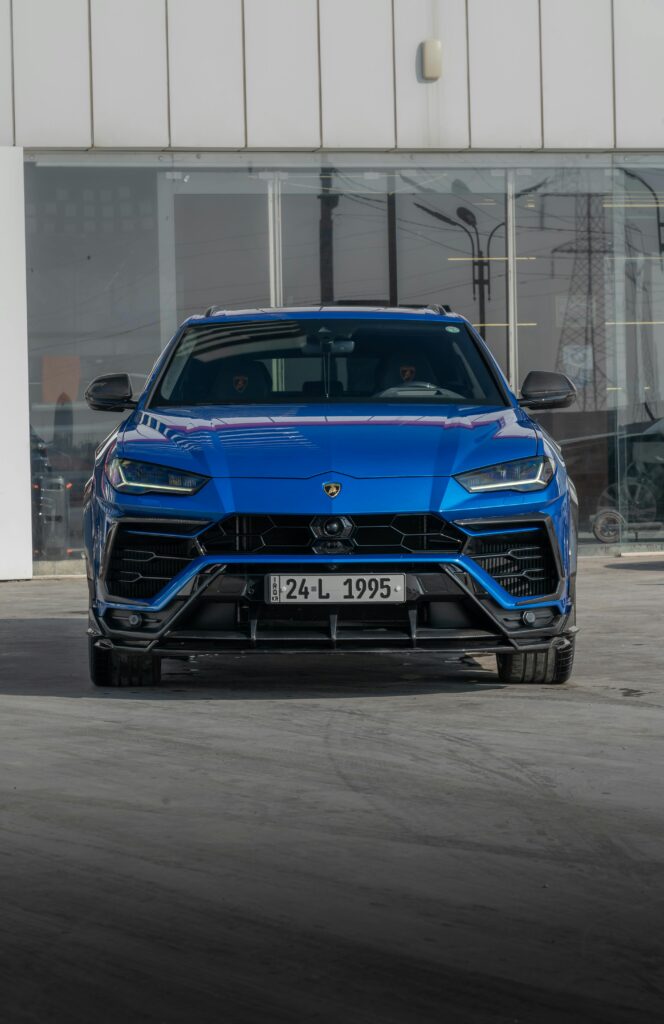 Front view of a striking blue Lamborghini Urus parked outdoors. Perfect for automotive enthusiasts.